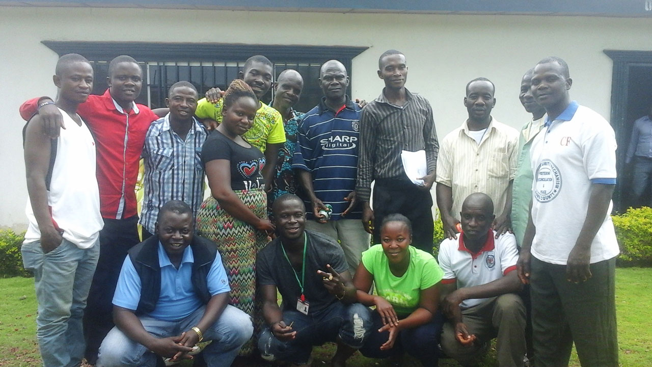 Group posing outside in front of a white building