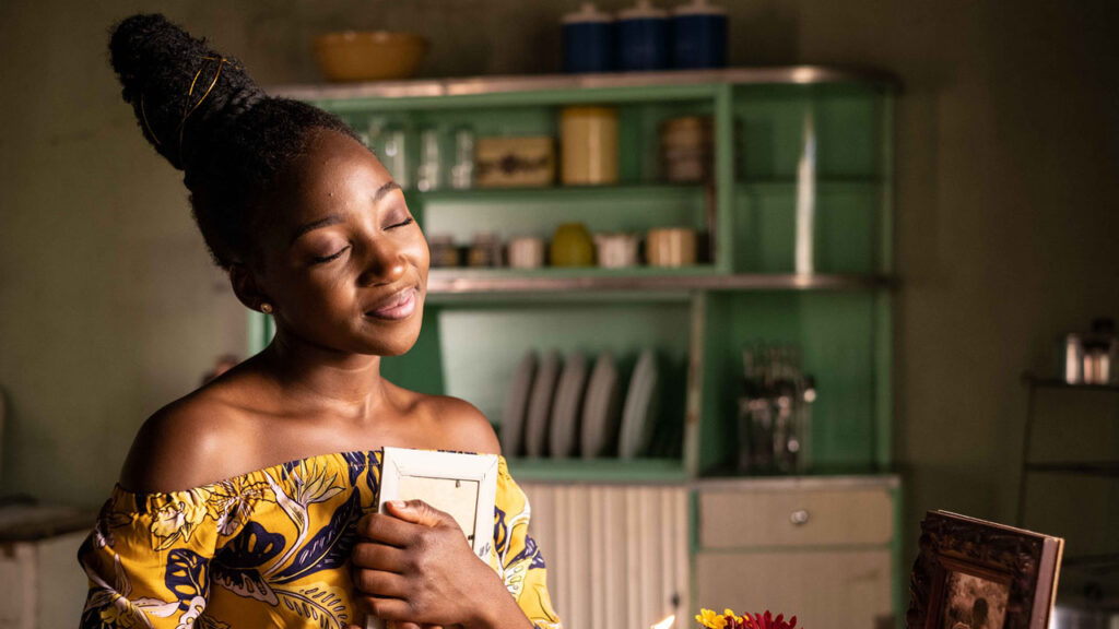 Girl holding picture frame and smiling with eyes closed