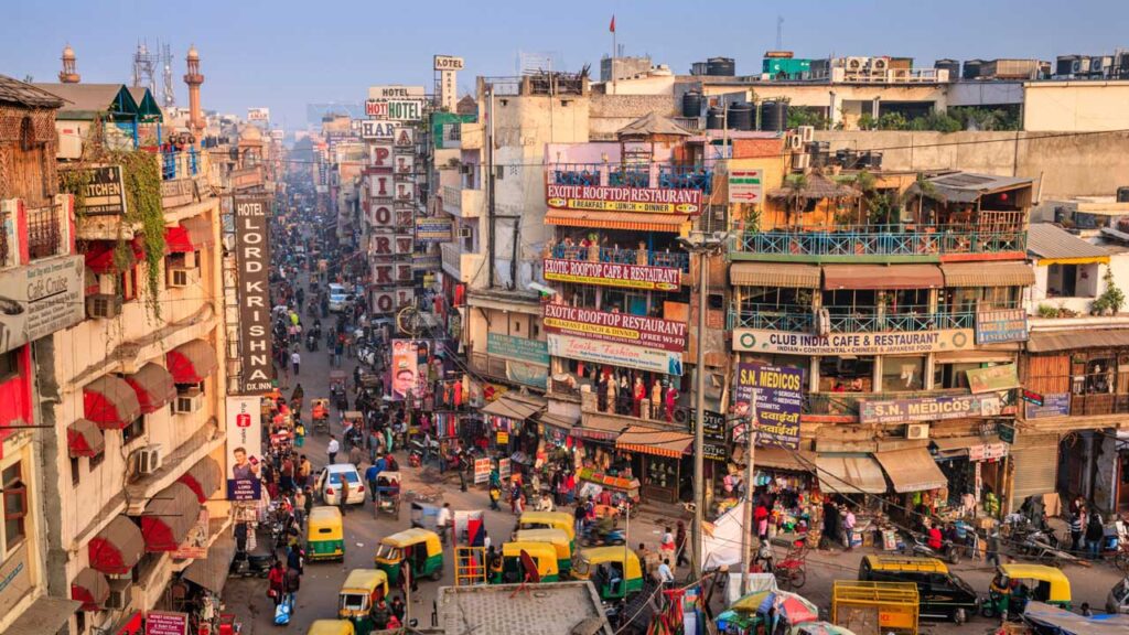 A busy and crowdy market with buildings and people moving around