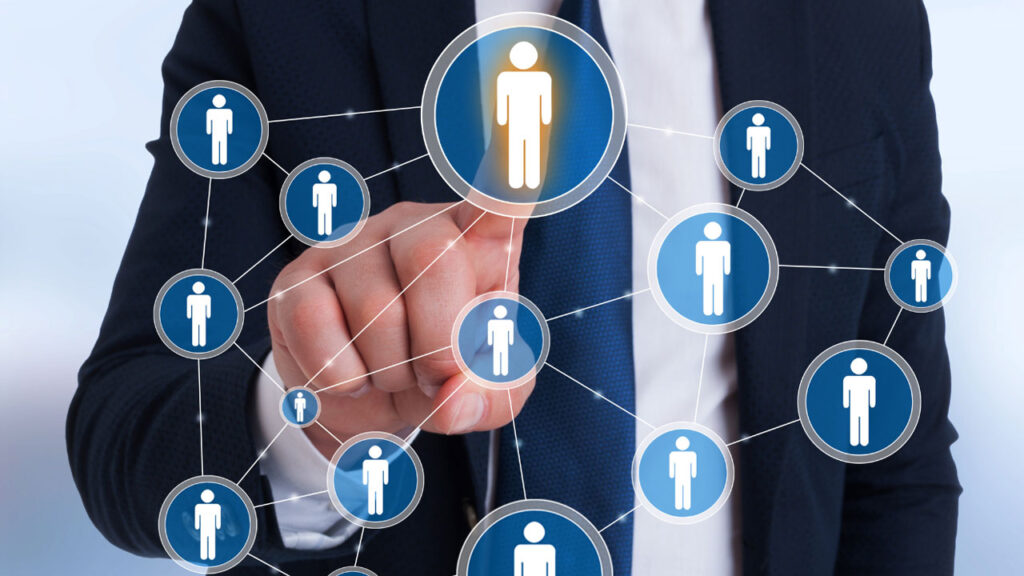 Man in suit pressing on an icon of a man who is connected others in a interconnected network