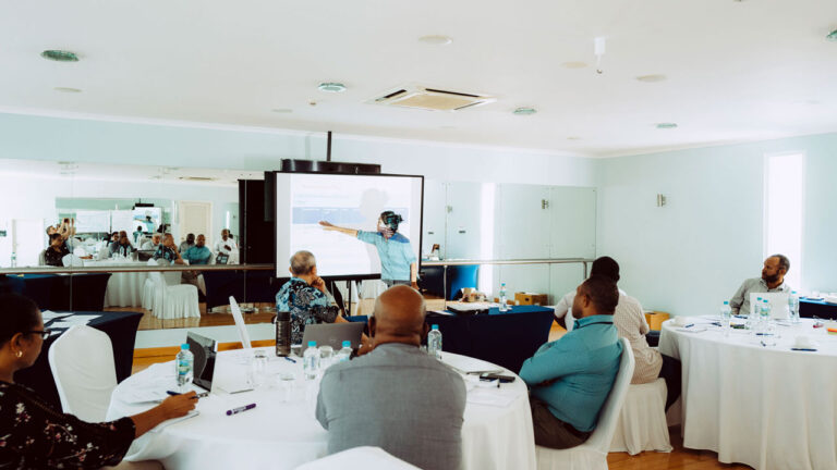 Trainer standing and pointing at a monitor while participants look on