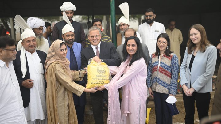 People posing with bag of soil